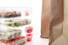 Stack Of Plastic Boxes With Sushi Roll Sets And Paper Bag. Food Delivery