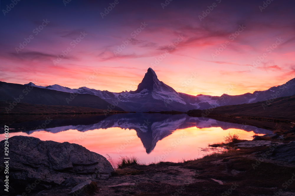 Picturesque landscape with colorful sunrise on Stellisee lake. Snowy Matterhorn Cervino peak with reflection in clear water. Zermatt, Swiss Alps - obrazy, fototapety, plakaty 