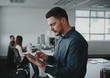 © StratfordProductions - Portrait of young businessman busy using digital tablet while his colleague working in background at modern office