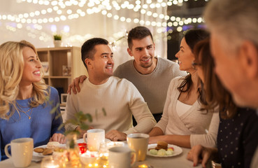 Wall Mural - celebration, holidays and people concept - happy family having tea party at home