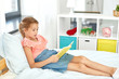 © Syda Productions - people, childhood and leisure concept - happy little girl reading book at home
