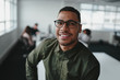© StratfordProductions - Portrait of charming successful young african american entrepreneur in shirt and eyeglasses looking at camera with smile in office