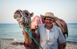 Camel owner on the coast of Tunisia with his camel, close-up