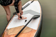 SUP / Stand up Paddle Board Get ready . Surfboard and paddle with Ankle Leash Rope Coiled Stand Up Paddle Board Surfing Cord String on a river lake water . Water sport, happy active summer vacation
