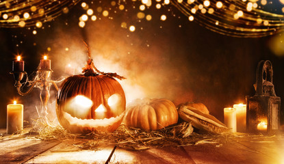 Spooky halloween pumpkin on wooden planks in dark cellar.