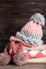 Canvas Print - Folded knitted sweaters with hat and scarf on wooden background