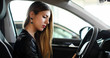 © Minerva Studio - Young woman examining a new car in a showroom