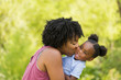 © digitalskillet1 - African American mother laughing and hugging her daughter.