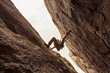 A rock climber pressing between two walls, between a rock and a hard place