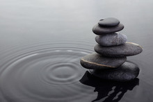 Zen Stones In Balanced Pile In Water On Rippled Water Surface.