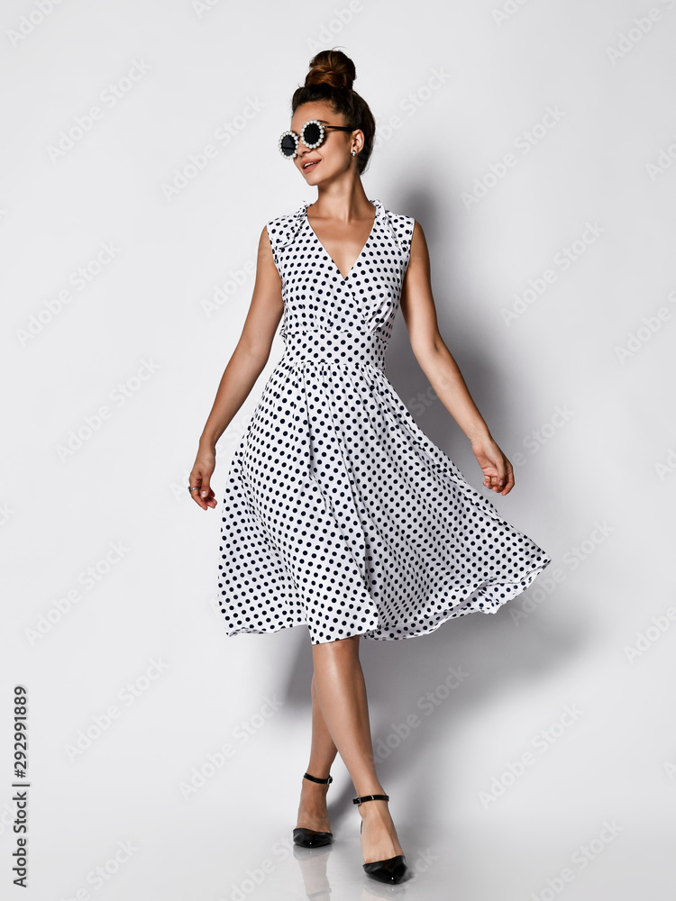 Full length portrait of happy beautiful woman in dress posing in studio ...