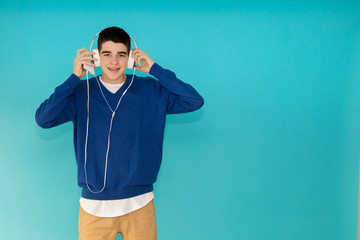 Canvas Print - young teenage man with mobile phone and trendy headphones isolated on color background