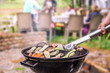 Closeup of a charcoal round gril and vegetables being grilled