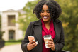 © digitalskillet1 - African American Woman texting and drinking coffee.