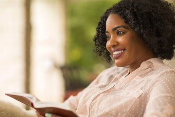 Wall Mural - African American woman studing and reading the Bible.