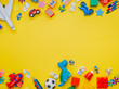 © lithiumphoto - Frame of kids toys on yellow background with copyspace
