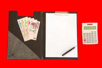 Calculator, folder and money on red background