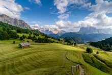 The green grass fields and a hut at the beautiful Val Gardena valley in Dolomites mountains, Alps, Italy.