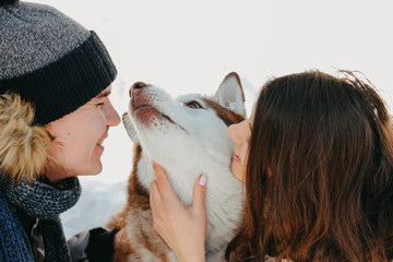 The happy couple with dog haski at forest nature park in cold season. Travel adventure love story