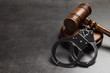 © New Africa - Judge's gavel and handcuffs on grey background, space for text. Criminal law concept
