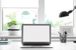 © New Africa - Modern laptop on desk near window at home