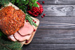 Homemade delicious ham on grey wooden background, flat lay with space for text. Festive dinner