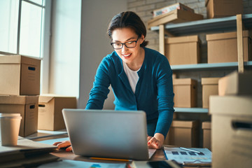 Woman is working at warehouse for online store.