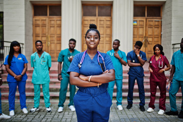 Wall Mural - Group of african medical students posed outdoor against university door.