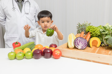 Wall Mural - Healthy and nutrition concept. Kid learning about nutrition with doctor to choose eating fresh fruits and vegetables.