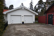 White new garage for two cars and wooden barn on private house yard.