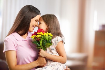 Wall Mural - Portrait of happy mother and daughter holding  flowers