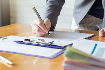 Business and finance concept of office working, Businesswoman holding pen and discussing Monthly Budget Chart