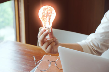 Idea of business person holding light bulb concept creativity with bulbs.