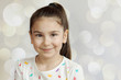 © kaganskaya115 - Portrait of happy smiling child girl on light background. Positive emotions.