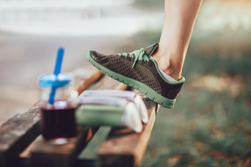 Woman raised her leg on the bench, after training in nature