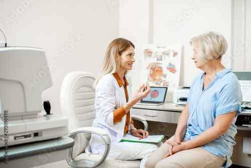 Fotomural Senior woman patient talking with female ophthalmologist during a medical consultation at the ophthalmologic office