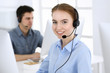 © Iryna - Group of operators at work. Call center. Focus on beautiful woman receptionist in headset at customer service. Business concept and casual clothing style