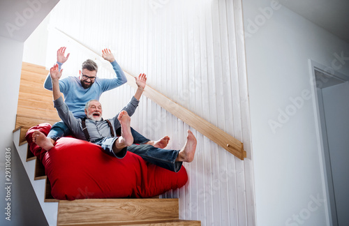 An adult hipster son and senior father indoors at home, having fun Poster Mural XXL