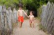 © Lisa Tichané - Young boy holding hands with toddler girl at beach