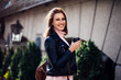© chichkaua - Stylish happy young woman wearing leather jacket and pink knitted sweater.She holds coffee to go. portrait of smiling girl in sunglasses and with bag