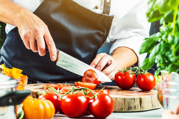 Poster - Koch schneidet frische rote Tomaten in Restaurant küche 