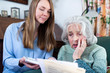 © Daisy Daisy - Woman Helping Worried Senior Neighbor Concerned About Debt With Bills And Paperwork