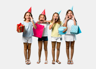set of little girl at a birthday party holding a gift bag shouting with mouth wide open on grey back