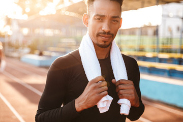 Sticker - Image of african american man standing on sports ground with towel