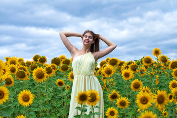 Portrait of a young beautiful girl in a field of sunflowers