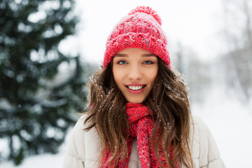 people, season and christmas concept - portrait of happy smiling teenage girl or young woman outdoors in winter park