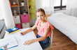 © Syda Productions - children, education and learning concept - student girl with book writing to notebook at home