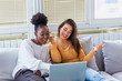 © Graphicroyalty - Portrait of a happy girlfriends surfing the net on laptop at home. Lovable caucasian and African American girls having fun at home