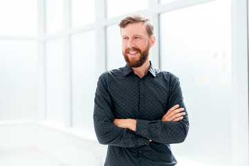 Wall Mural - smiling businessman standing near the office window