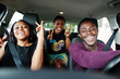 Young african american friends sitting inside a car.